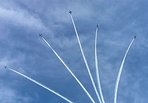 ブルーインパルスが扇形に広がるスモーク演技