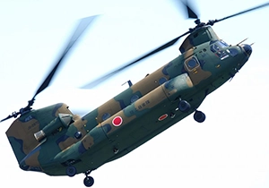 ローターを傾けて飛行するCH-47JA輸送ヘリコプター