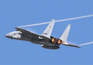 両翼からベイパーを引きながら飛ぶF-15